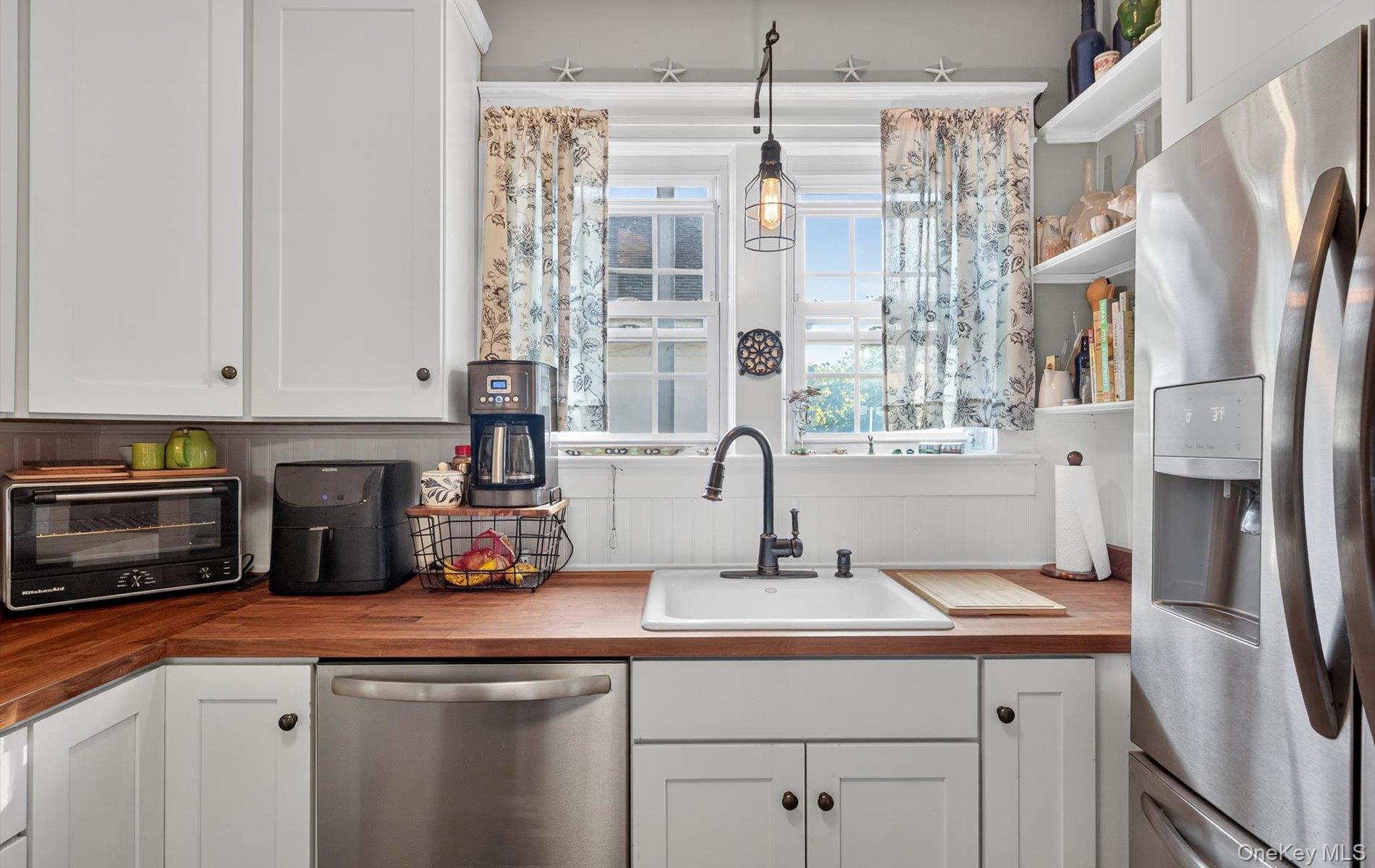 7 Ransom Avenue Sea Cliff, NY 11579 - Photo 19 of 42 a kitchen with stainless steel appliances a sink and a refrigerator