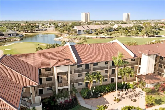 an aerial view of residential houses with outdoor space and ocean view