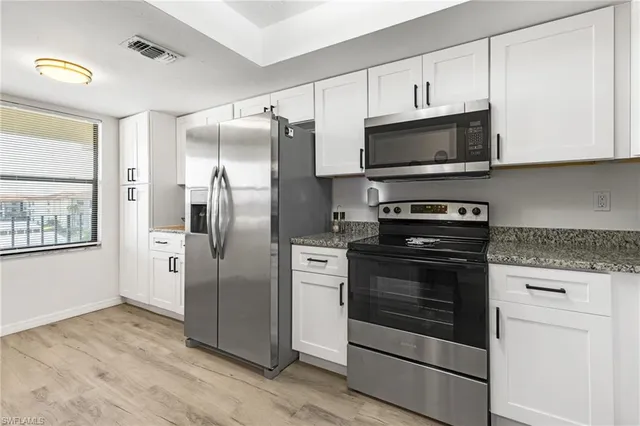 a kitchen with stainless steel appliances granite countertop a refrigerator stove and microwave