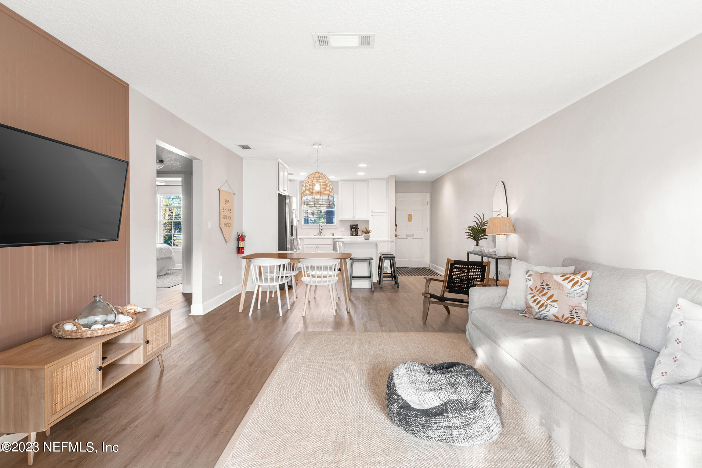 405 Flagler Boulevard, Unit 2A St. Augustine, FL 32080 - Photo 11 of 30 a living room with furniture a flat screen tv and kitchen view