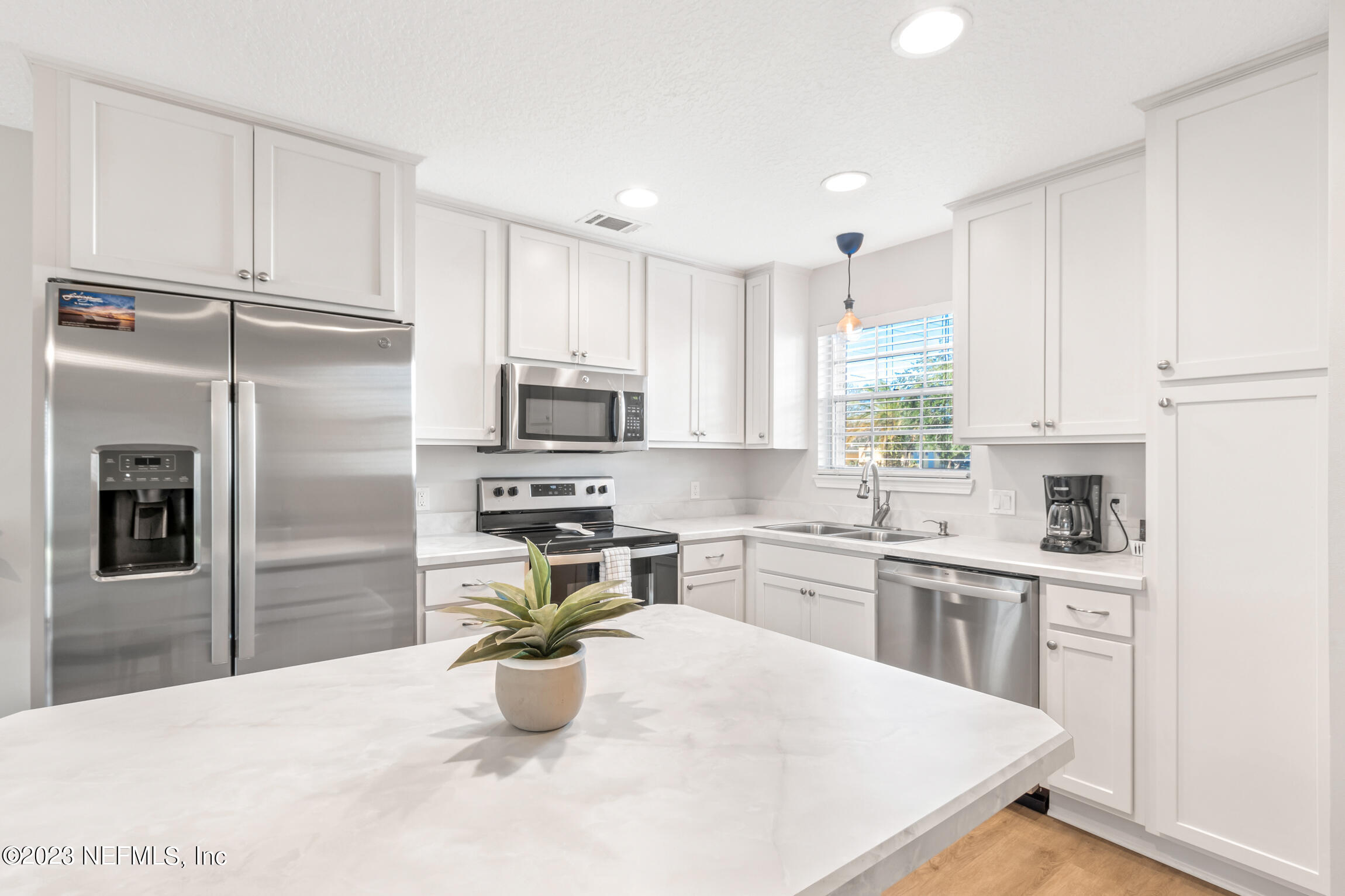 405 Flagler Boulevard, Unit 2A St. Augustine, FL 32080 - Photo 6 of 30 a kitchen with stainless steel appliances kitchen island granite countertop a refrigerator sink and stove