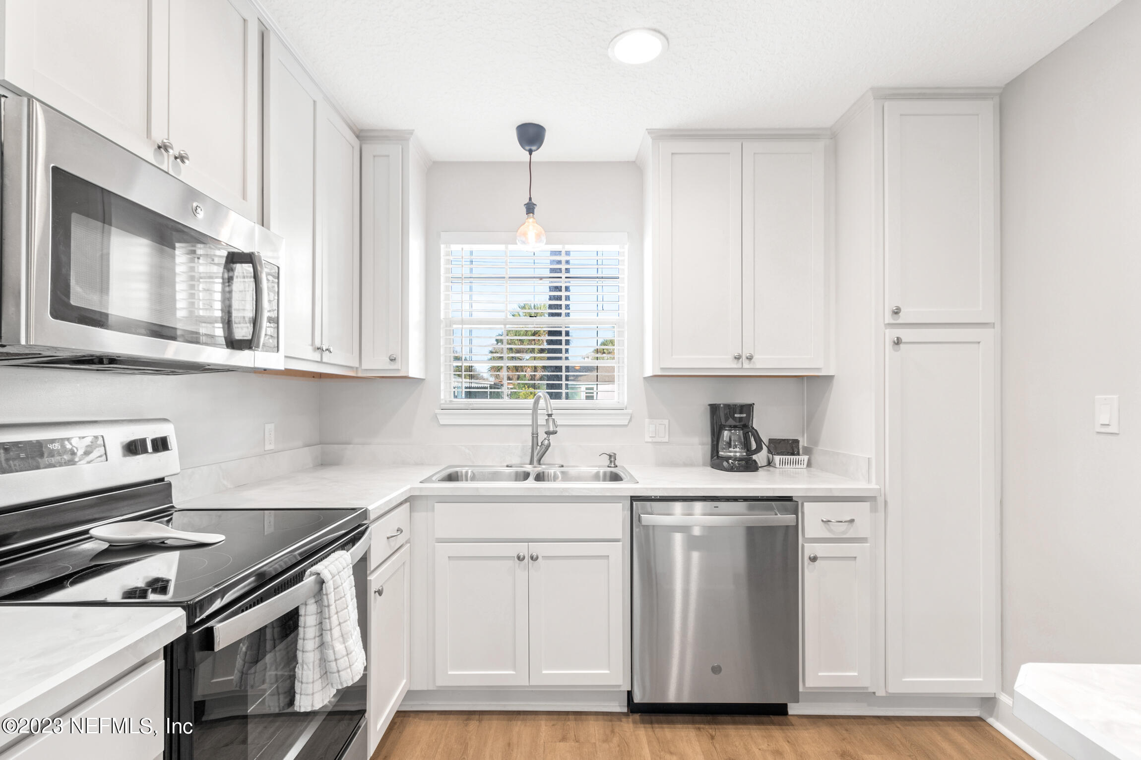 405 Flagler Boulevard, Unit 2A St. Augustine, FL 32080 - Photo 7 of 30 a kitchen with stainless steel appliances granite countertop a sink stove and cabinets