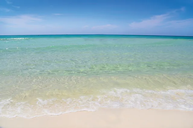 a living room with furniture kitchen view and a chandelier