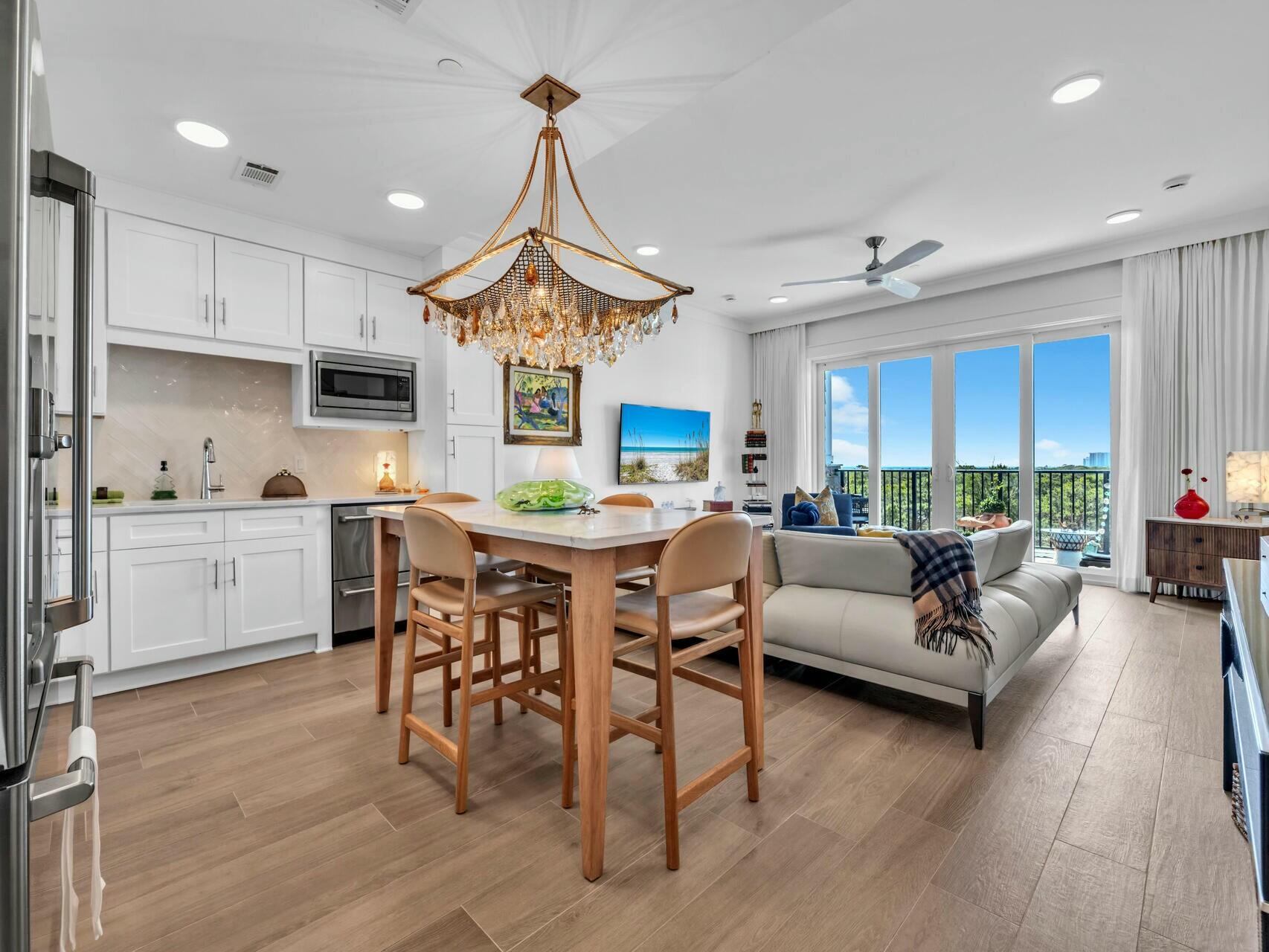 206 Henderson Resort Way, Unit 5202 Destin, FL 32541 - Photo 12 of 55 a living room with furniture a dining table wooden floor and a fireplace