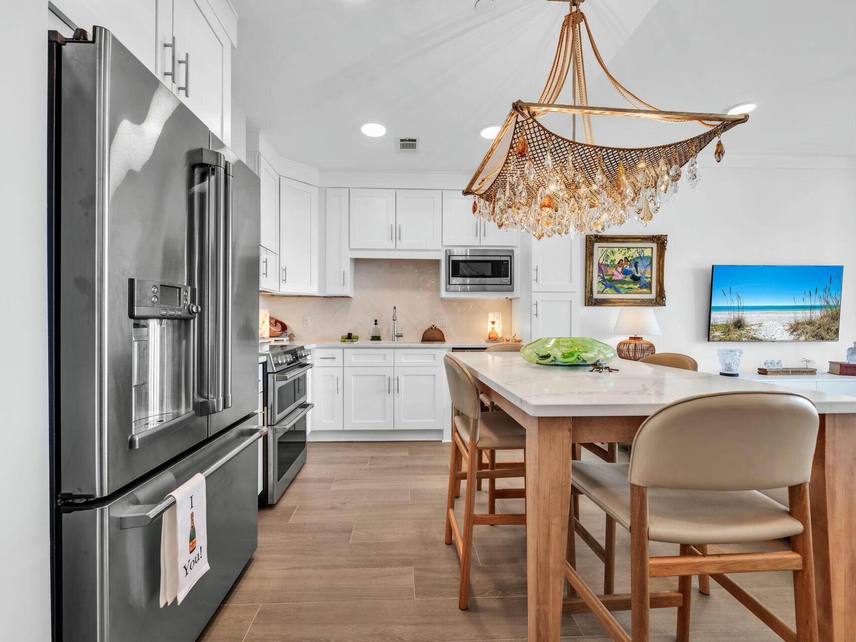 206 Henderson Resort Way, Unit 5202 Destin, FL 32541 - Photo 13 of 55 a kitchen with stainless steel appliances granite countertop a sink a stove a refrigerator and island