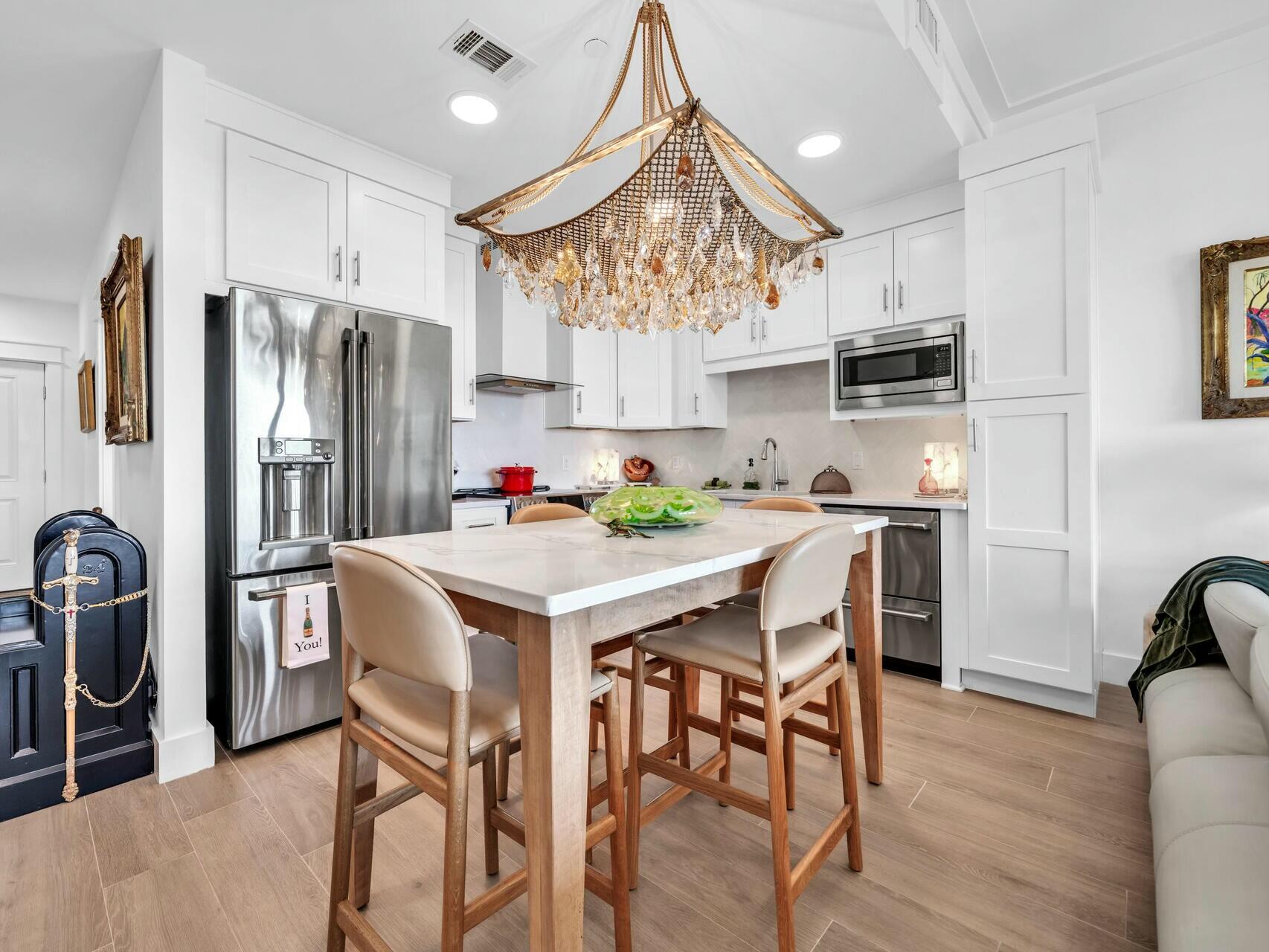 206 Henderson Resort Way, Unit 5202 Destin, FL 32541 - Photo 14 of 55 a kitchen with stainless steel appliances granite countertop a dining table chairs refrigerator and sink