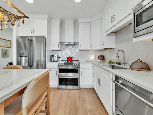 a kitchen with stainless steel appliances granite countertop white cabinets a sink and dishwasher