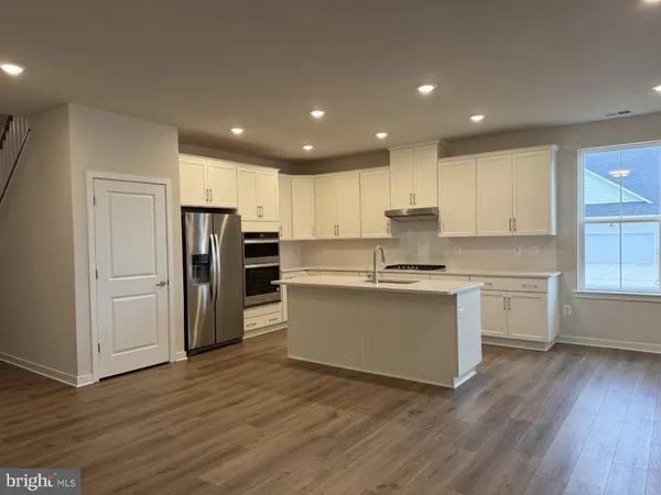 a kitchen with a refrigerator and white cabinets