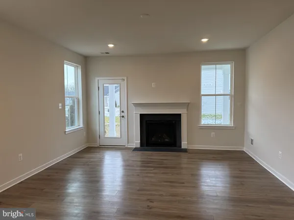 a view of empty room with wooden floor and fireplace