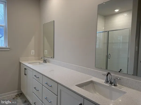 a bathroom with a double vanity sink and a mirror