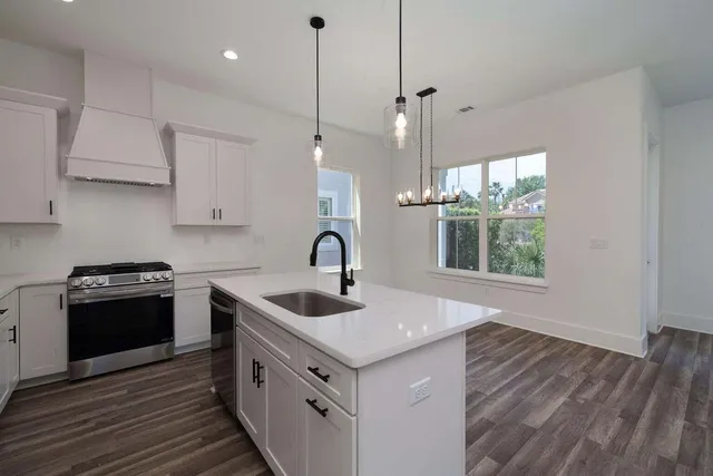 a kitchen with a sink stove top oven and cabinets