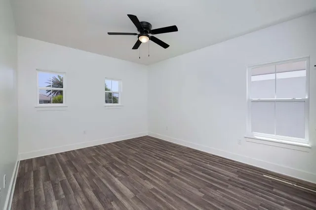 a view of empty room with wooden floor and window