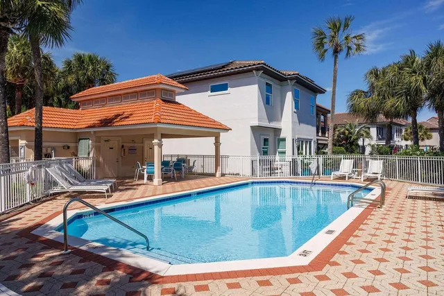 a view of a house with pool and sitting area