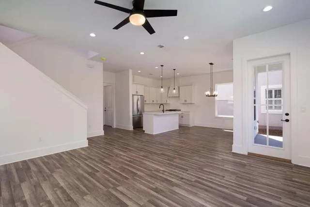a view of a kitchen with wooden floor and windows