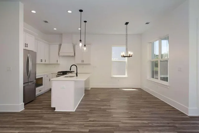 a view of a kitchen with kitchen island a sink wooden floor and a window