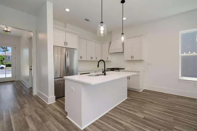 a kitchen with kitchen island a sink stainless steel appliances and cabinets