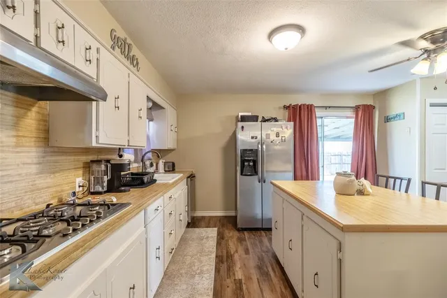 a kitchen with granite countertop a sink stove and refrigerator
