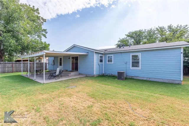 a view of a house with a yard and sitting area