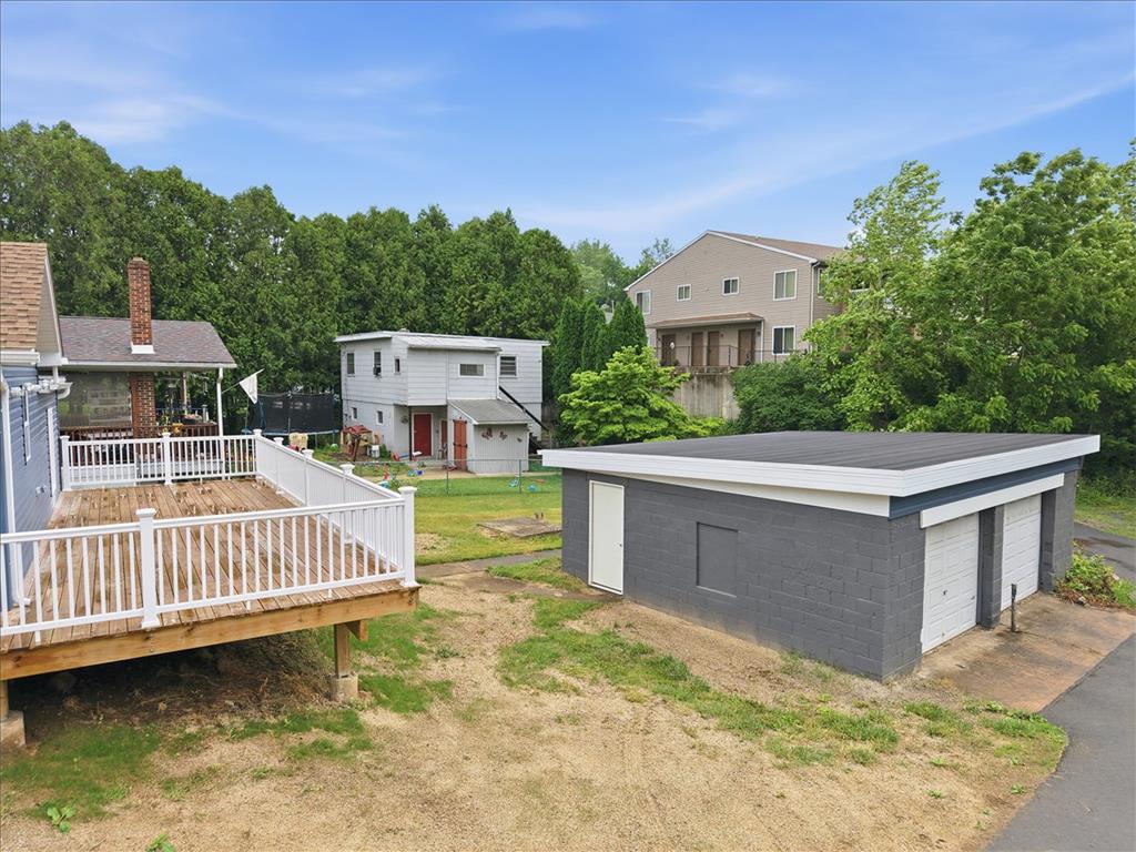5641 North Coplay Road Whitehall, PA 18052 - Photo 56 of 68 A spacious wooden deck extends from a home with a detached two-car garage, offering ample outdoor living and parking.