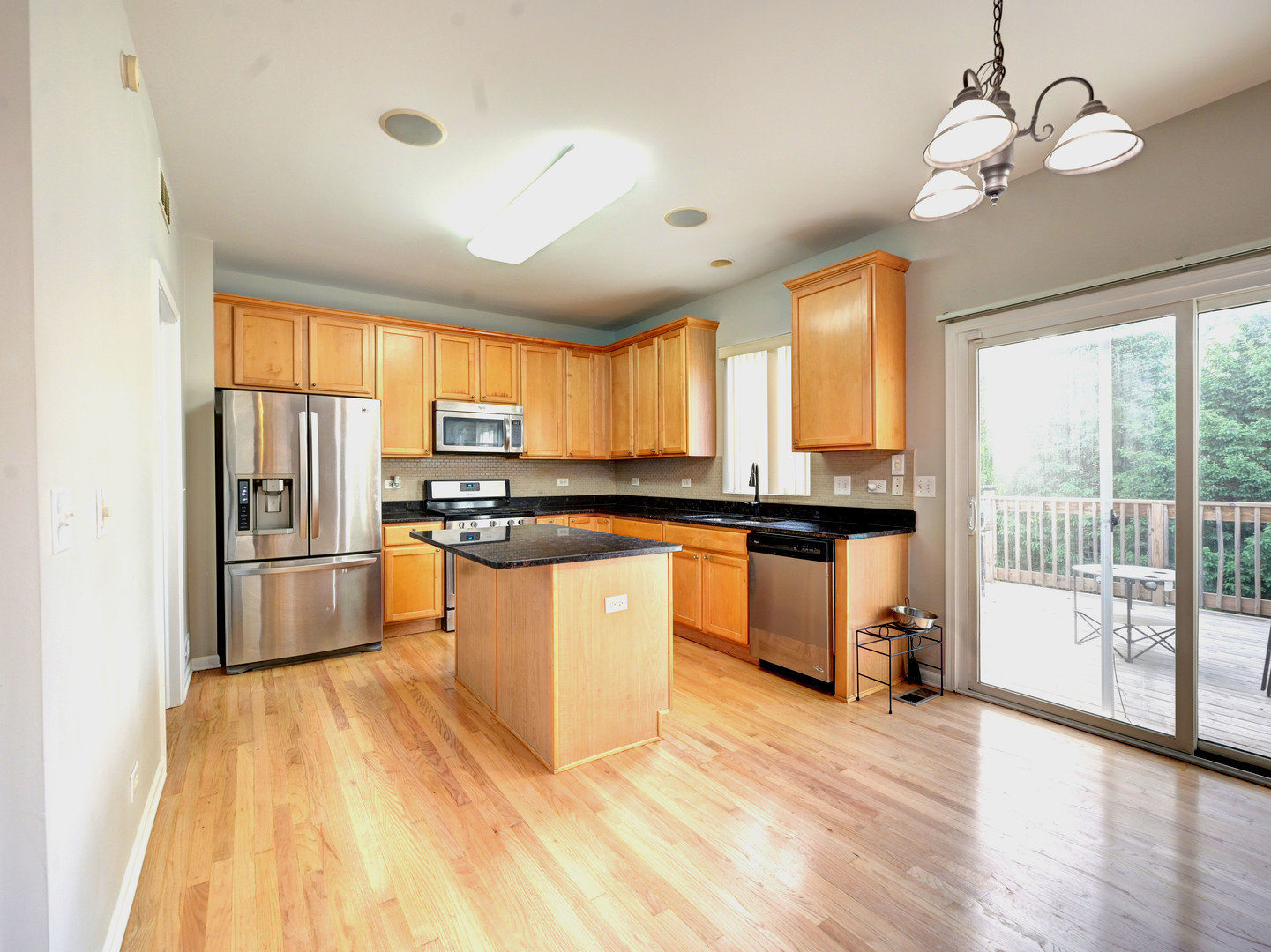 6 Forsythia Court Bolingbrook, IL 60490 - Photo 11 of 28 a kitchen with granite countertop a stove top oven a sink dishwasher a dining table and chairs with wooden floor