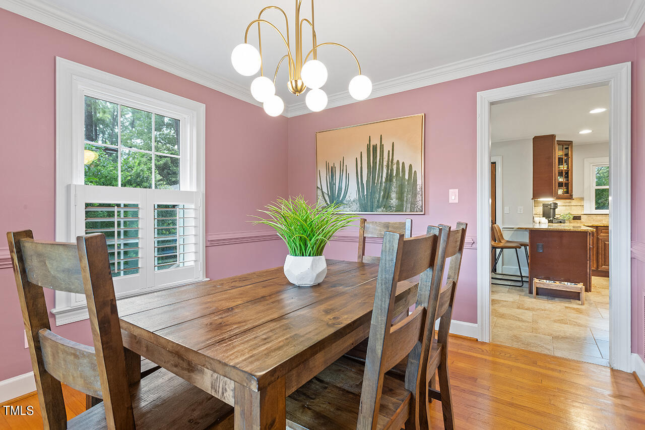4918 Quail Hollow Drive Raleigh, NC 27609 - Photo 11 of 36 a dining room with furniture potted plants and wooden floor