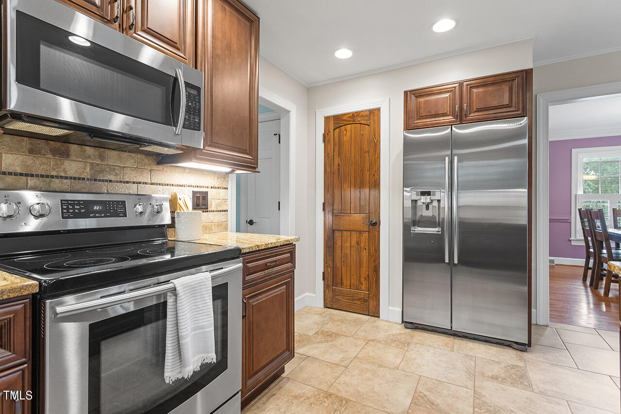 4918 Quail Hollow Drive Raleigh, NC 27609 - Photo 15 of 36 a kitchen with stainless steel appliances granite countertop a stove a refrigerator and a microwave