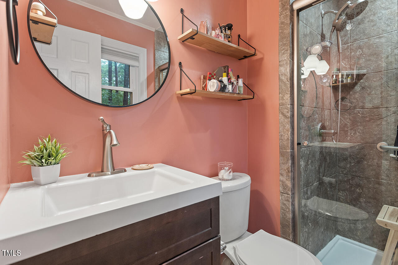 4918 Quail Hollow Drive Raleigh, NC 27609 - Photo 24 of 36 a bathroom with a sink mirror toilet and shower