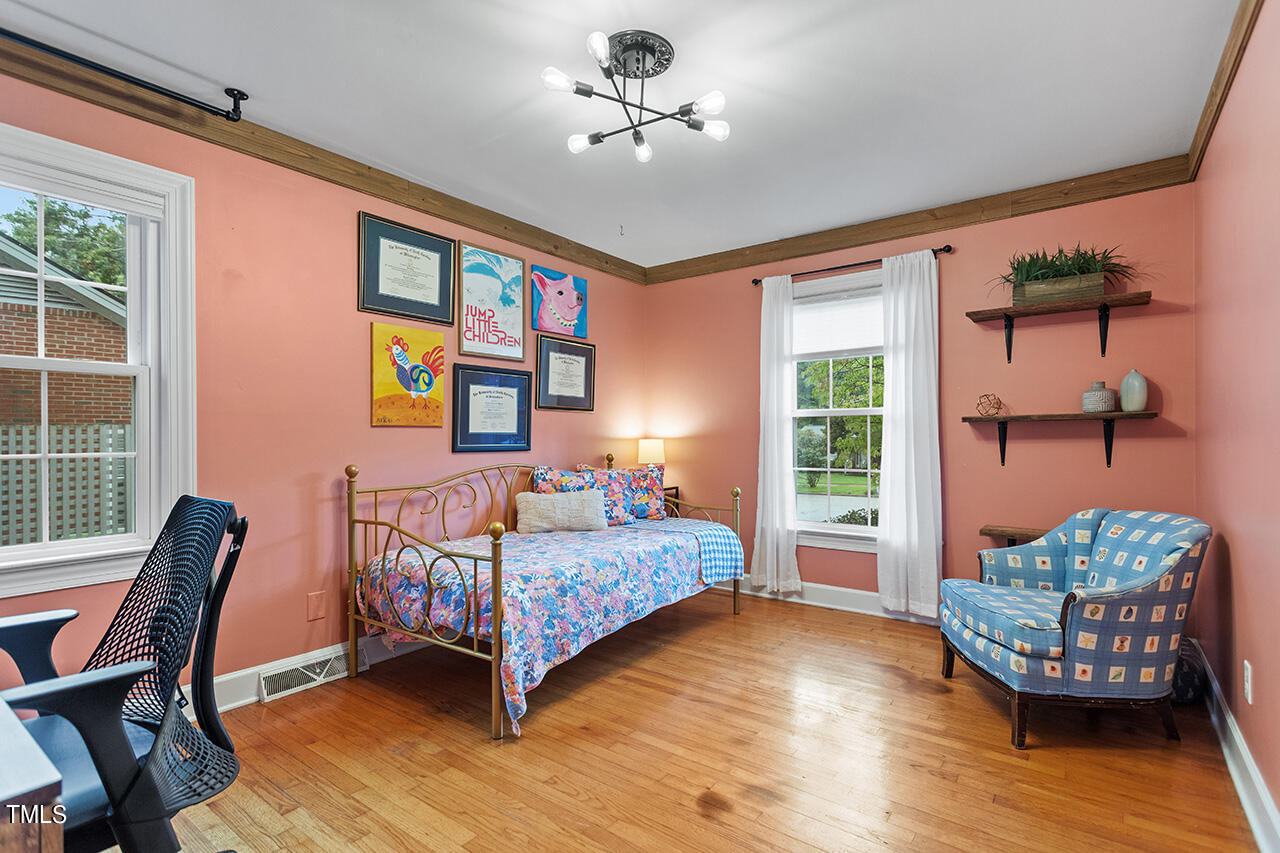 4918 Quail Hollow Drive Raleigh, NC 27609 - Photo 26 of 36 a bedroom with a bed wooden floor and a window
