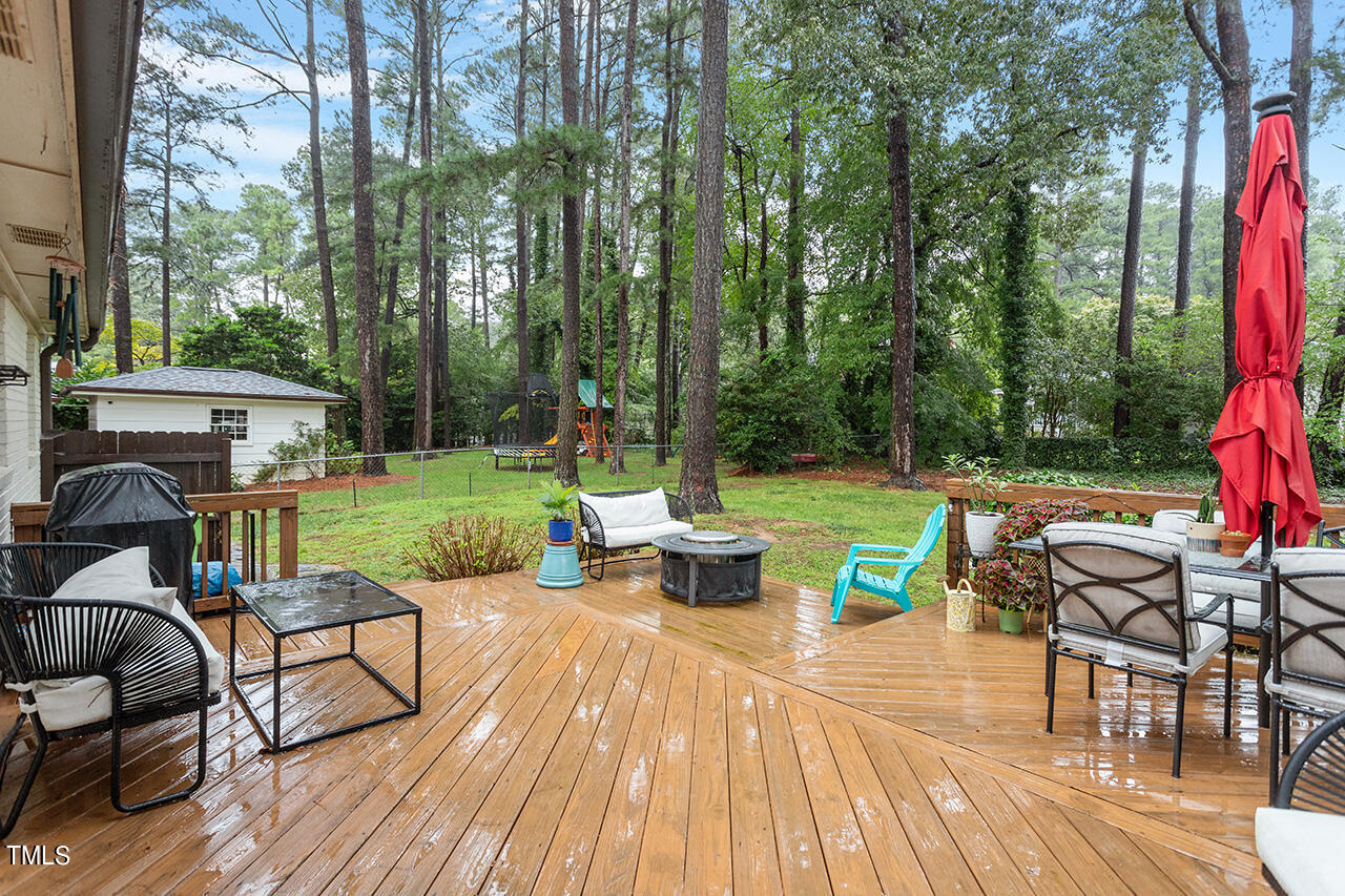 4918 Quail Hollow Drive Raleigh, NC 27609 - Photo 31 of 36 a view of a patio with dining table and chairs with wooden floor and fence