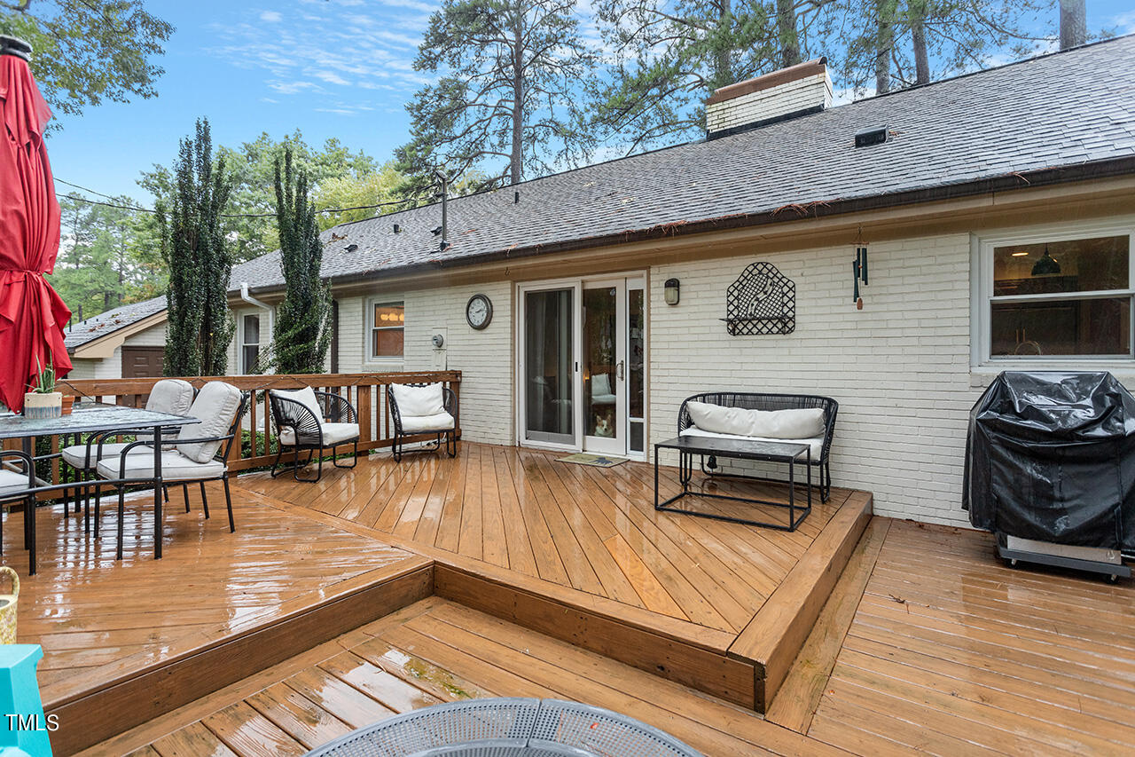 4918 Quail Hollow Drive Raleigh, NC 27609 - Photo 32 of 36 a view of a patio with dining table and chairs with wooden floor and fence
