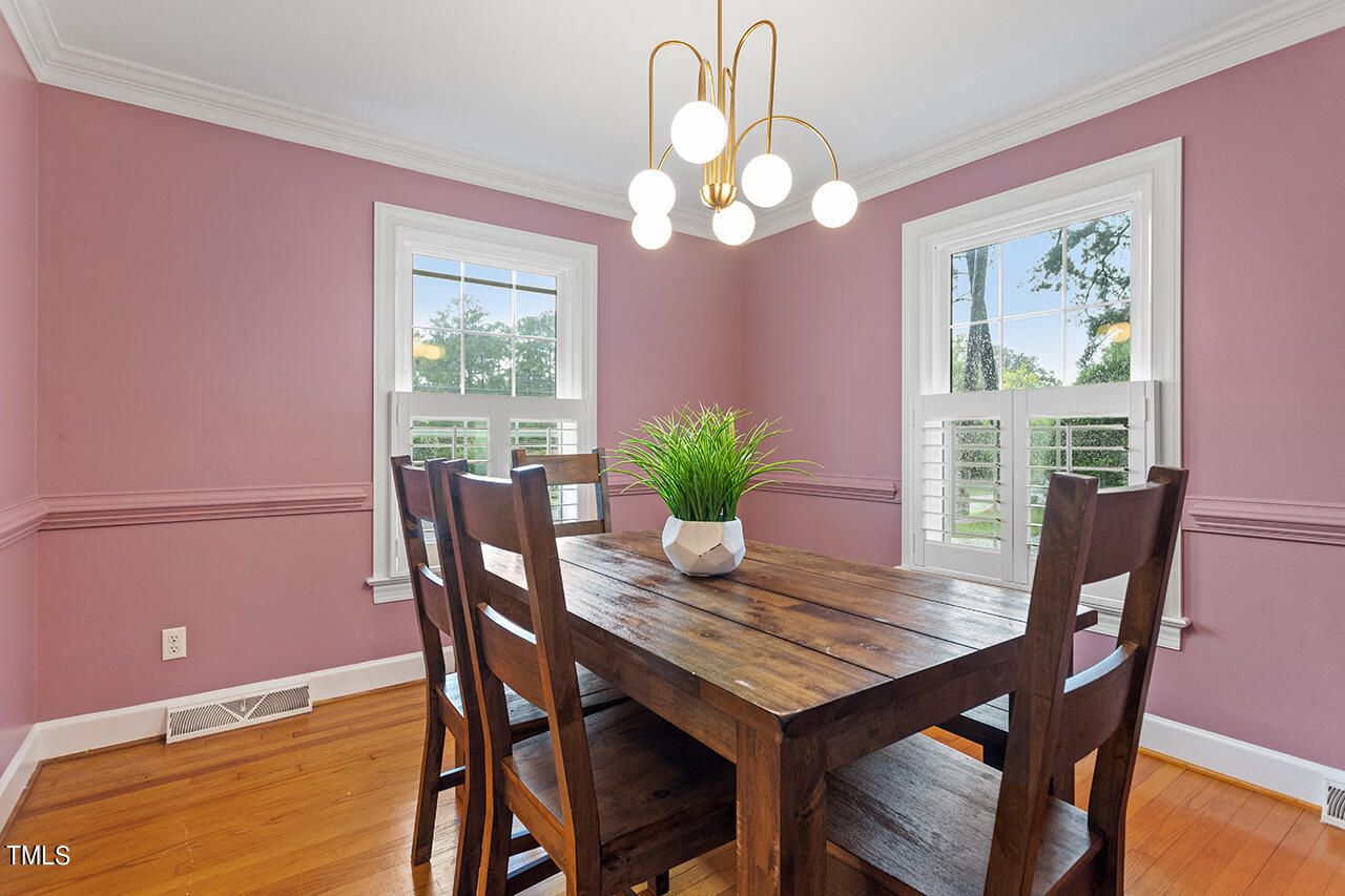 4918 Quail Hollow Drive Raleigh, NC 27609 - Photo 10 of 36 a view of a dining room with furniture a chandelier and wooden floor