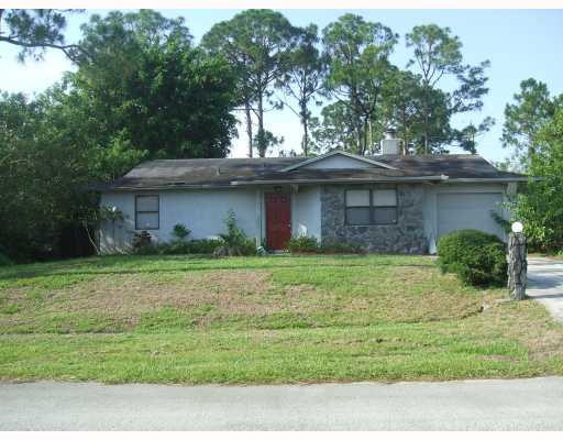 2864 Southwest Seaside Road Port St. Lucie, FL 34953 - Photo 1 of 5 a front view of a house with a garden