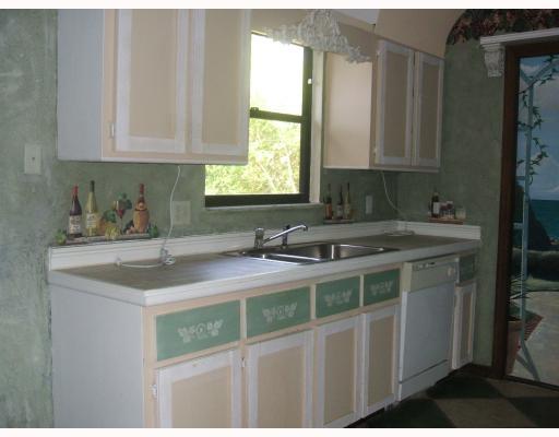 2864 Southwest Seaside Road Port St. Lucie, FL 34953 - Photo 4 of 5 a kitchen with stainless steel appliances granite countertop a sink stove and cabinets