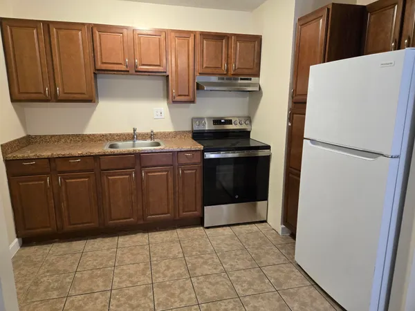 a kitchen with a stove top oven and cabinets