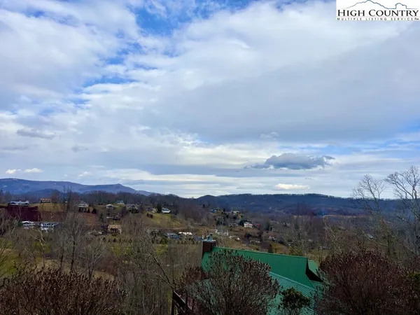 an aerial view of residential house with green space and mountain view