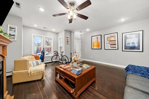 a living room with furniture and a ceiling fan