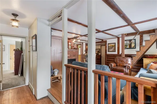a view of staircase with lots of frames on wall and wooden floor