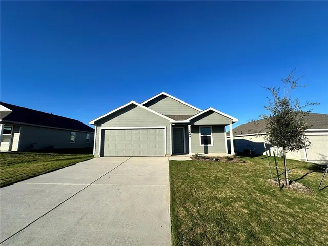 a front door view of a house with a yard and garage
