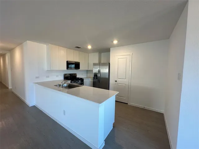 a kitchen with wooden cabinets and a refrigerator