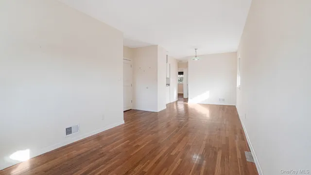 a view of a room with wooden floor and white walls