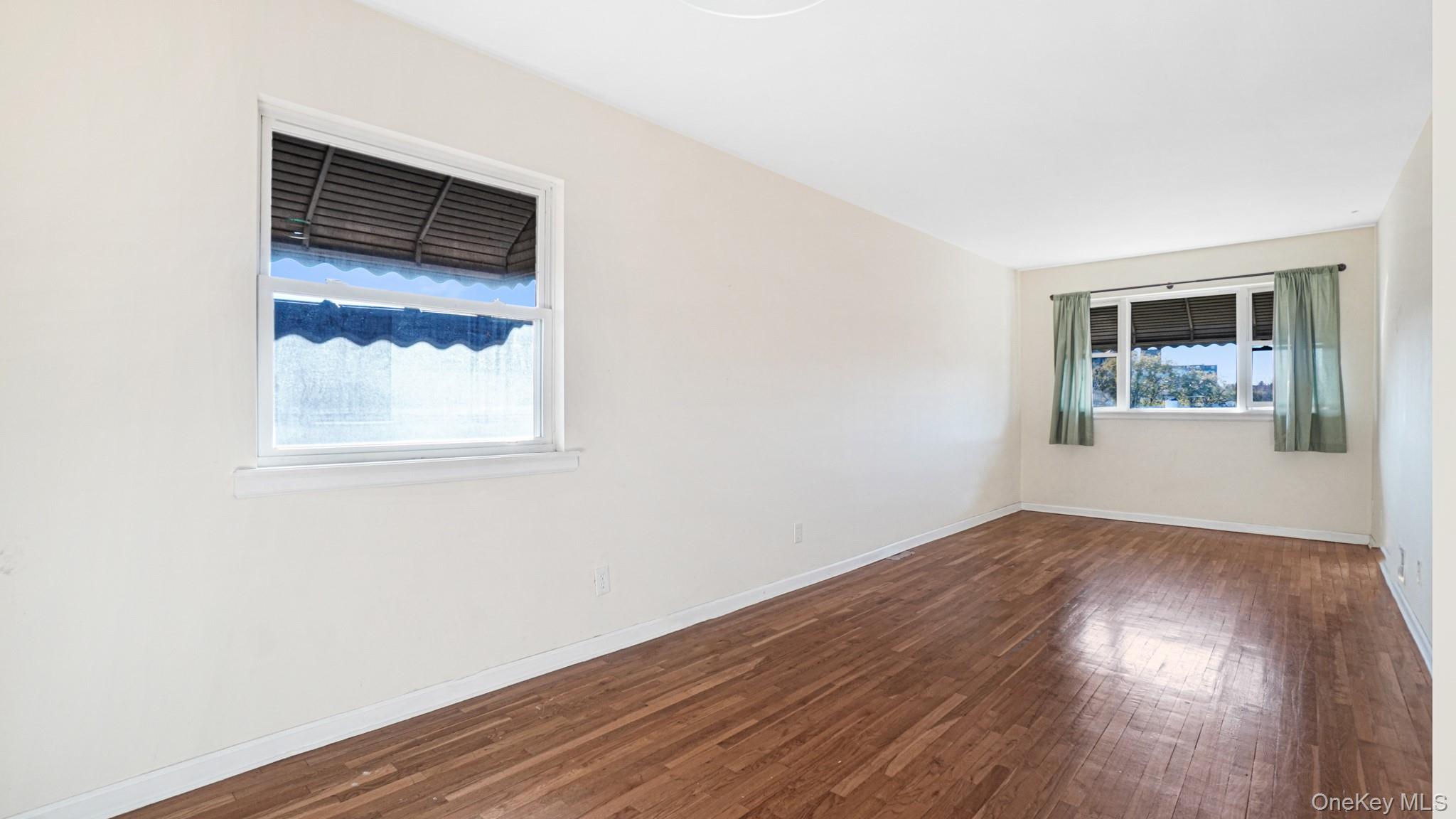 1270 Rosedale Avenue Bronx, NY 10472 - Photo 15 of 19 an empty room with wooden floor and windows