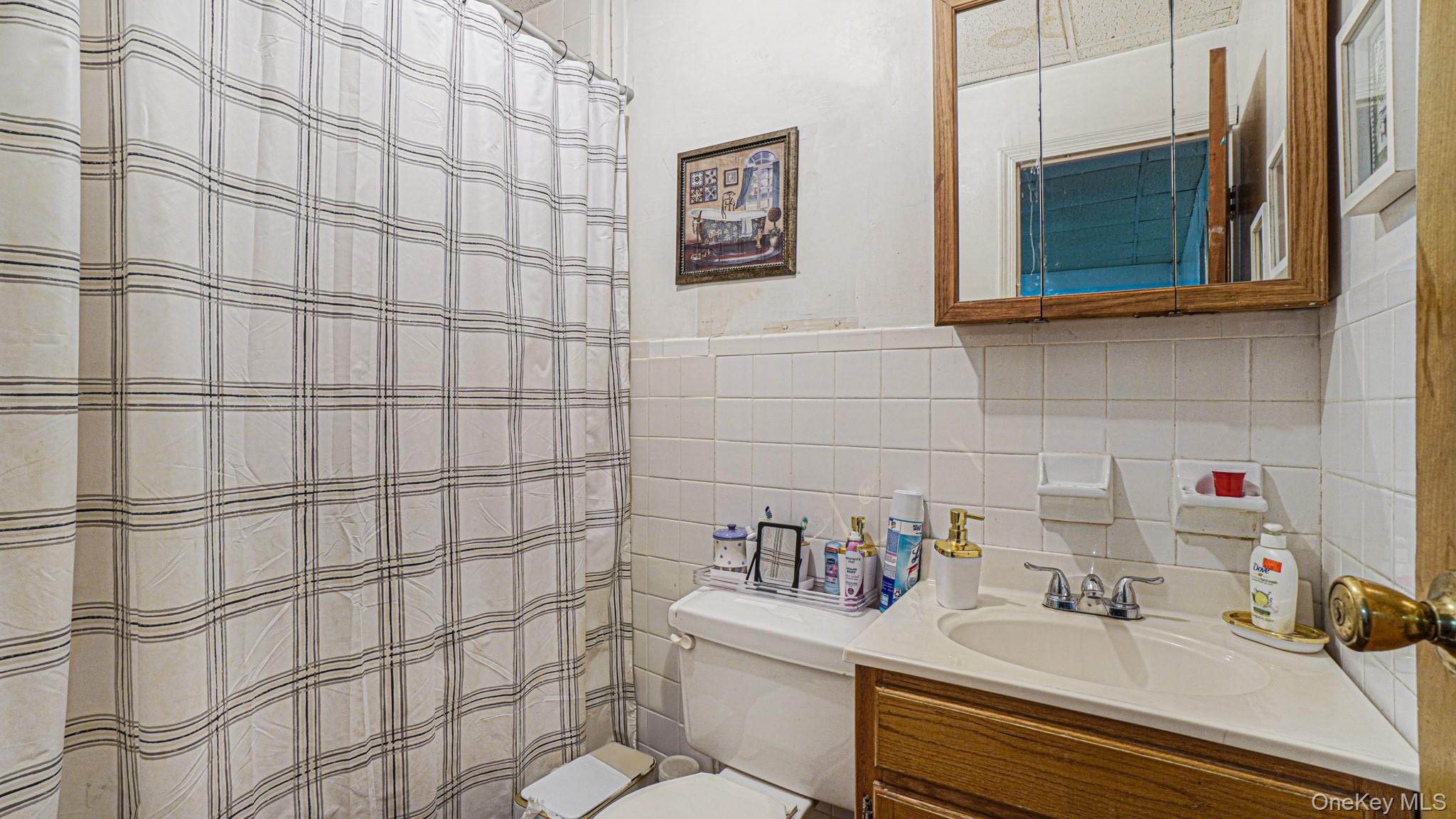 1270 Rosedale Avenue Bronx, NY 10472 - Photo 17 of 19 a bathroom with a sink and a shower curtain