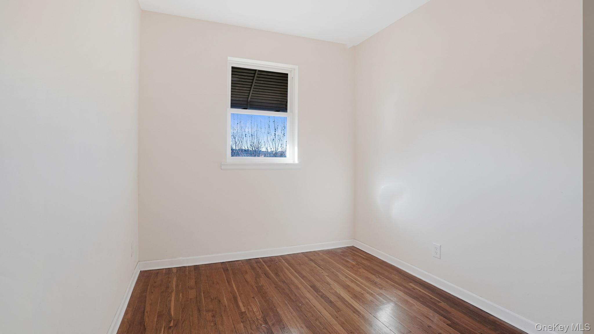 1270 Rosedale Avenue Bronx, NY 10472 - Photo 7 of 19 a view of an empty room with wooden floor and a window