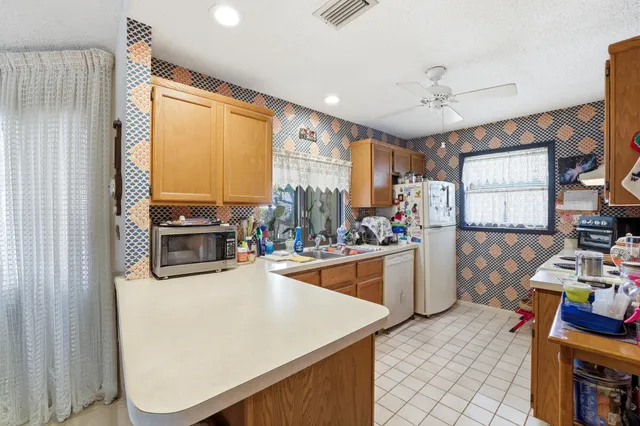 a kitchen filled with stainless steel appliances kitchen island granite countertop a sink stove and cabinets