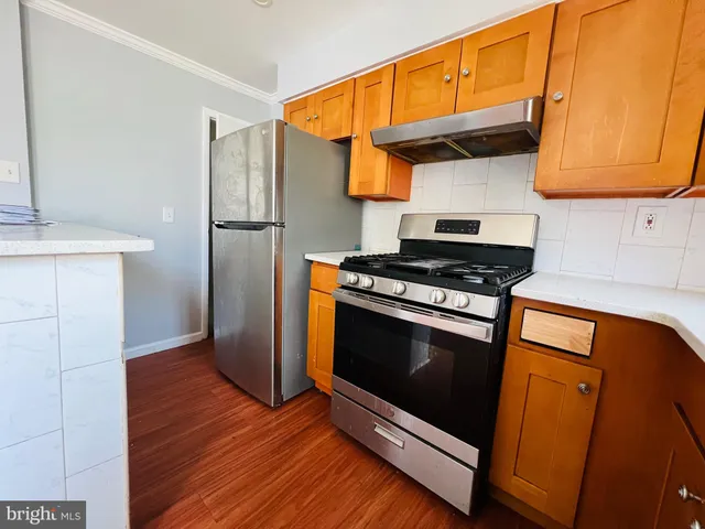 a kitchen with granite countertop wooden floors and a stove