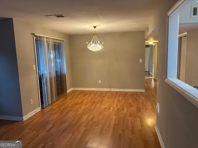 an empty room with wooden floor and a window