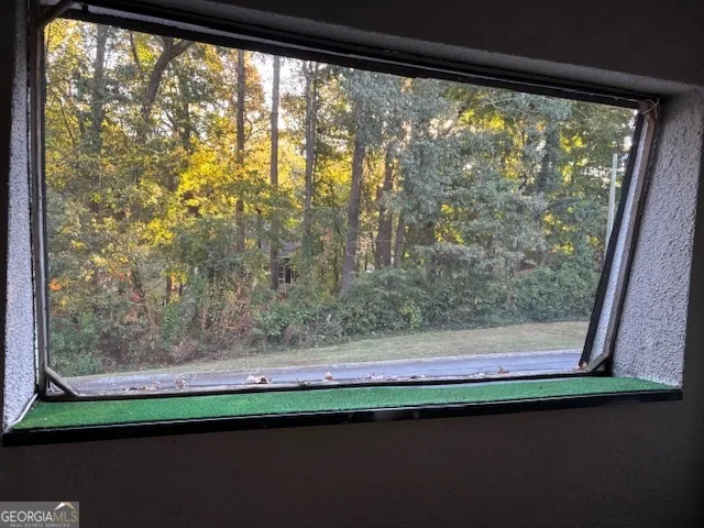 a view of a room with wooden floor a chandelier fan and windows