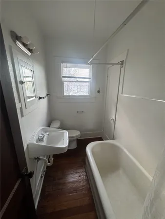 a bathroom with a sink a toilet a mirror and shower