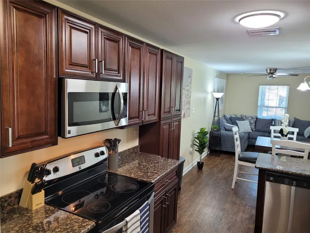 a kitchen with stainless steel appliances granite countertop a refrigerator a stove a sink and a refrigerator