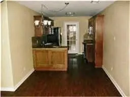 a view of a hallway with wooden floor and a dining room